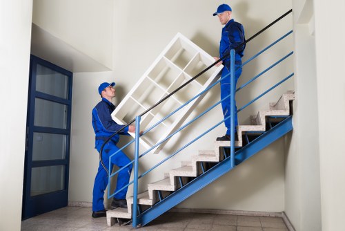 Professional movers carrying boxes in a Stockwell home