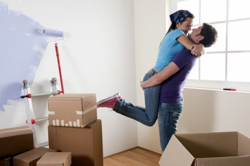 Two movers carrying furniture from a terrace house