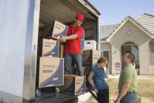 Professional movers carrying household items from a Stockwell property