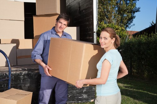 Movers carrying household furniture through a Stockwell staircase